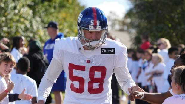 Oct 7,, 2022; Thundridge, United Kingdom; New York Giants long snapper Casey Kreiter (58) is greeted by children during practice at Hanbury Manor.